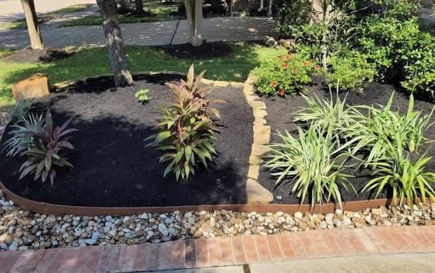 Flower bed after fresh mulch and stone edging by Arvo Landscapes, Cypress TX